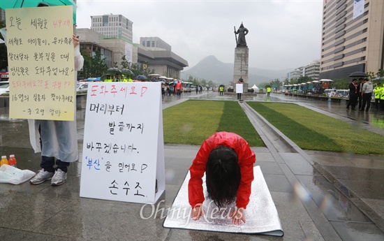 "도와주세요" 대 "표 구걸?" 6.4지방선거를 하루 앞둔 3일 오후 손수조 새누리당 당협위원장이 서울 광화문광장에서 '도와주세요! 머리부터 발끝까지 바꾸겠습니다. '부산'을 믿어요! 손수조'가 적힌 피켓을 놓고 절을 하고 있다. 옆에서는 '중·고생 엄마'라고 밝힌 시민이 '오늘 세월호 49재. 세월호 아이들이, 유가족들이 살려달라 울부짖을 때 당신들은 도와주었나요? 도와주세요?? 표 구걸?? 16명의 실종자 찾아주세요'가 적힌 피켓을 들고 1인 시위를 하고 있다.