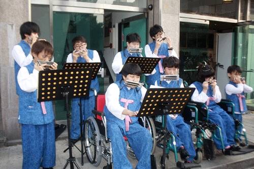 특별초청되어 연주하고 있는 성보학교 맑은소리하모니카연주단의 연주 광경.