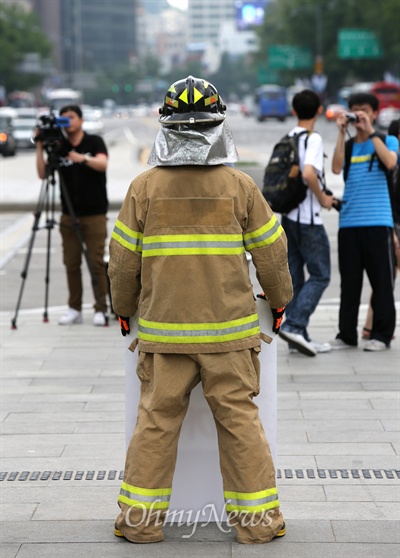 지난 9일 오후 서울 광화문광장에서 화재진압복을 입은 소방관이 지방직인 소방관의 '국가직 전환' '현장대응 소방인력 증원' '낡고 부족한 장비 현대화' 등을 요구하며 릴레이 1인 시위를 벌이고 있다.