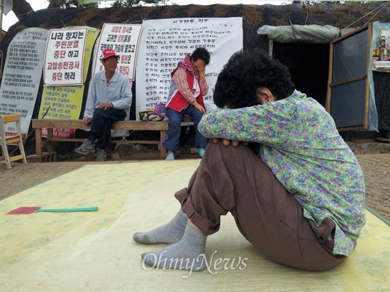 밀양시와 경찰이 11일 새벽 송전탑 반대 움막농성장을 강제철거하는 행정대집행에 나설 예정인 가운데 10일 오후 밀양시 부북면 장동마을 입구 움막에 주민들이 밧줄과 의자로 바리게이트를 설치해놓고 걱정하며 앉아있다.