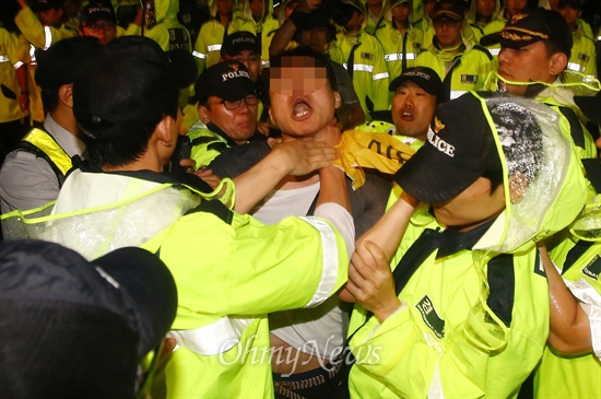 10일 오후 서울 종로구 국무총리 공관 앞에서 열린 '박근혜퇴진 6.10 청와대 만인대회'에서 경찰들이 한 참가자를 연행하고 있다.