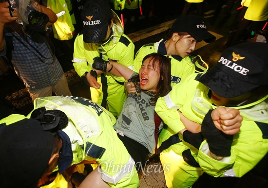 10일 오후 서울 종로구 국무총리 공관 앞에서 '박근혜퇴진 6.10 청와대 만인대회'를 참석했던 학생들이 경찰과 대치 도중 청와대 진입을 시도하자 한 참가자를 연행하고 있다.