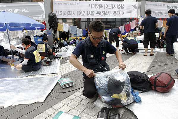 20일 아침 잠자리에서 일어난 삼성전자서비스지회 조합원이 침낭과 잠자리 짐을 정리하고 있다. 