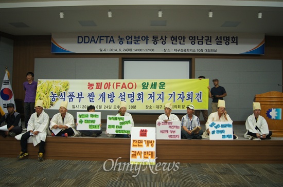  전농 경북도연맹 소속 농민들이 대구상공회의소에서 열린 쌀개방 설명회인 'DDA/FTA 농업분야 통상 현안 영남권 설명회'를 막기 위해 단상에 앉아 있는 모습. 