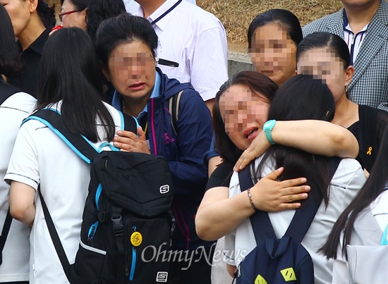 세월호침몰사고 단원고 희생자 유가족들이 25일 오전 경기 안산 단원고에서 치료 뒤 첫 등굣길에 오른 2학년 학생들을 안아 주고 있다.
