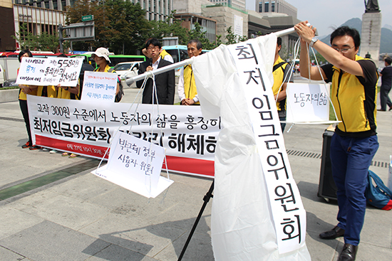 알바노조가 노동자의 삶보다 박근혜 정부와 사용자 위원에게 힘을 싫어주는 최저임금위원회를 비판하는 퍼포먼스를 펼치고 있다.