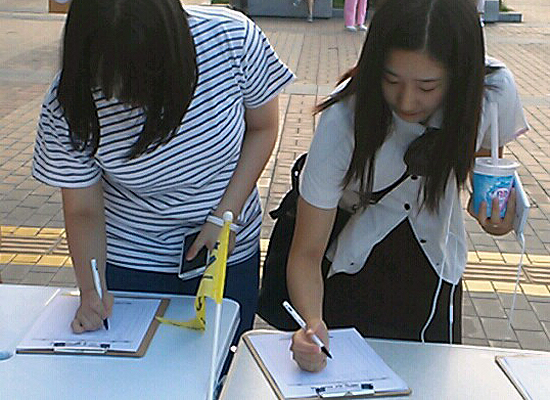 평택역 앞에서 열린 '세월호 참사 진상규명 서명운동' 중에 두 여학생이 서명하는 모습
