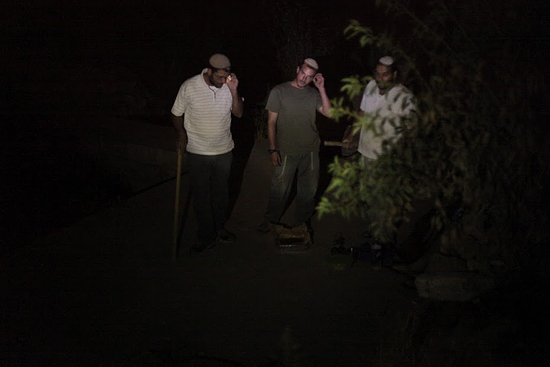 2012년 8월, 다라그마씨 집에 급습하는 정착민들, 손에는 큰 나무막대기를 들고 있다. 