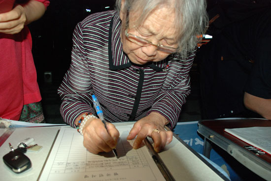 세종시 한솔동 첫마을 90살 구서희 할머니가 며느리의 부축을 받으며 찾아와 서명하고 있다. 