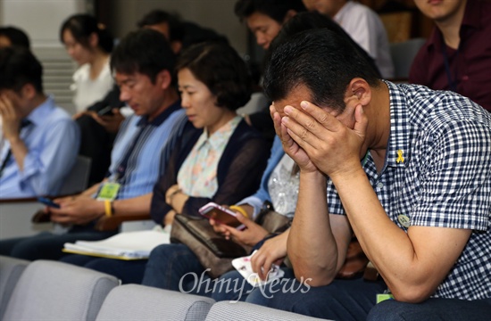  세월호 국정조사 특위 소속 새누리당 의원들이 지난 2일 "김광진 새정치민주연합 의원이 청와대와 해경간 녹취록을 왜곡해 박근혜 대통령을 모욕했다"며 "김 의원이 특위 위원직을 사퇴할 때까지 기관보고를 진행할 수 없다"고 밝혀 파행을 빚자, 참관중이던 유가족이 얼굴을 감싸쥐고 있다. 