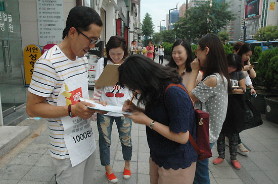 세월호 천만인 서명 김제동이 강남역을 지나가는 시민들에게 다가가 세월호 사고 진상규명과 재발방지를 촉구하는 서명을 받고 있다. 