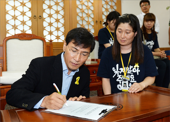 안희정 충남지사가 9일 세월호 유가족들을 만난 자리에서 '세월호 특별법 제정을 위한 광역단체장 서명서'에 서명하고 있다.
