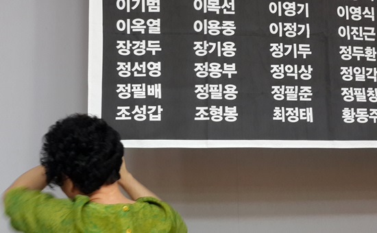 충남 공주지역 한국전쟁민간인인희생자 위령제에서 한 유가족이 희생자 이름을 어루만지며 눈물을 흘리고 있다. 