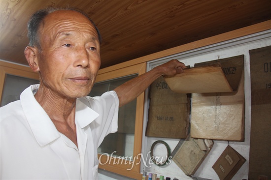  경남 사천 용현면 신복리에 있는 '박연묵 교육박물관'에서 박연묵 관장이 1961년에 도안해 놓은 '수예(자수)' 디자인을 모은 '디자인북'을 살펴보며 설명하고 있다.