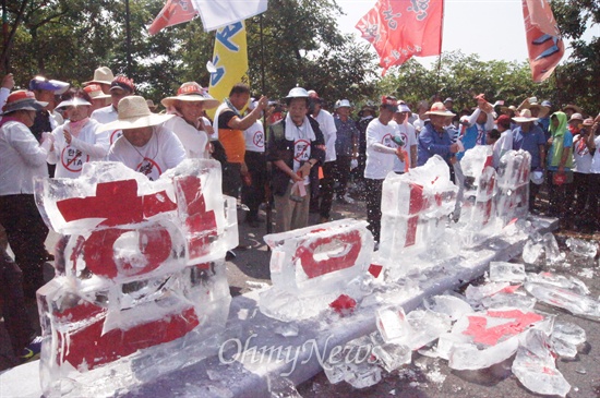 한중FTA를 반대하는 농민대회가 14일 오후 대구시 북구 산격동 산격대교 앞에서 열린 가운데 농민들이 얼음으로 만든 '한중FTA'글자를 망치로 깨고 있다.