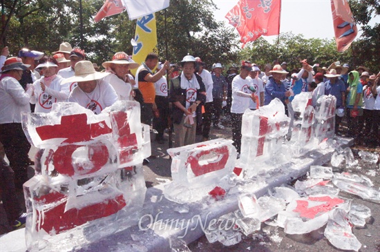  한중FTA를 반대하는 농민대회가 14일 오후 대구시 북구 산격동 산격대교 앞에서 열린 가운데 농민들이 얼음으로 만든 '한중FTA'글자를 망치로 깨고 있다.