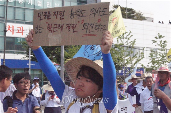  한중FTA반대 농민대회가 14일 오후 대구에서 열린 가운데 한 농민이 한중FTA 협상이 벌어지고 있는 대구엑스코를 향해 거리행진을 하다 경찰의 차벽에 막히자 손으로 쓴 피켓을 높이 들어보이고 있다.