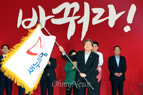 14일 오후 서울 잠실실내체육관에서 열린 새누리당 제3차 전당대회에서 새 당대표로 선출된 김무성 의원이 당기를 받아들고 있다.
