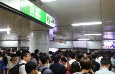 15일 오전, 출근시간 대 열차 지연으로 승객이 몰려 탑승하지 못하고 있다.