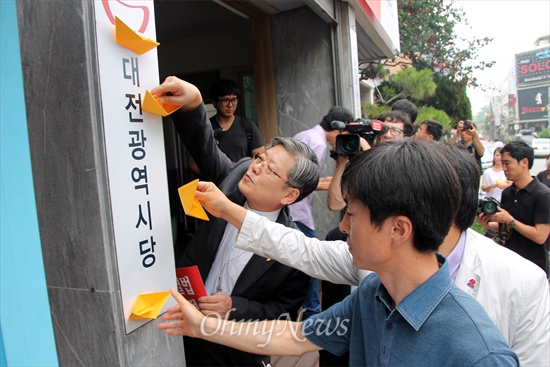  기자회견에 참석한 '세월호 참사 대전대책회의' 대표들이 새누리당 대전시당사에 노란 종이배를 붙이는 퍼포먼스를 벌이고 있다.