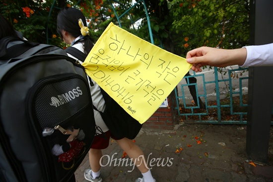 세월호침몰사고 생존 단원고 학생들이 15일 경기도 안산에서 국회를 향한 도보 행진에서 "하나의 작은 움직임이 큰기적을 20140416"이 적힌 깃발을 가방에 꽂고 있다.
