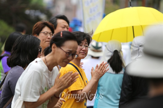 눈물 글썽이며 격려하는 시민들 '친구들의 억울한 죽음, 진실을 밝혀주세요'가 적힌 현수막을 앞세운 세월호 침몰사고 생존 단원고 2학년 학생들이 16일 오전 희생된 친구들의 부모들이 '제대로된 특별법 제정'을 촉구하며 단식농성중인 국회를 향해 이틀째 도보행진을 벌이고 있다. 학생들이 구로구를 지나는 가운데 도로에 나온 시민들이 격려를 하며 눈물을 글썽이고 있다.