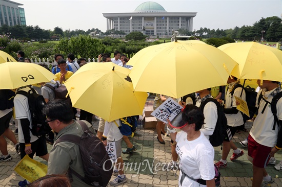 "친구들의 억울한 죽음, 진실을 밝혀달라"며 1박2일 동안 도보행진을 한 안산 단원고 생존 학생들이 노란 우산을 쓰고 16일 오후 서울 여의도 국회 정문 앞에 도착하고 있다.