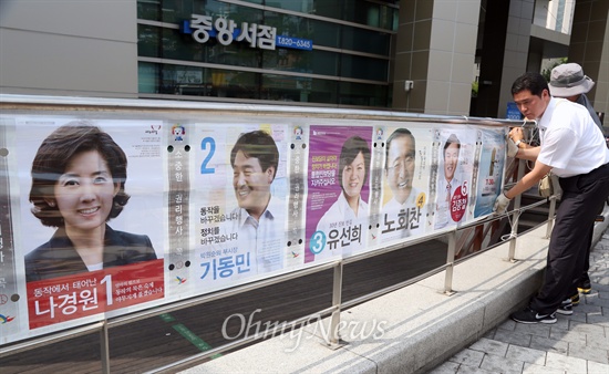 지난 2014년 7.30 재보선 공식 선거운동이 시작된 7월 17일 오전 서울 동작구 선거관리위원회 관계자들이 서울 동작구 중앙대 정문 앞에 동작을 후보자 선거벽보를 부착하고 있다.