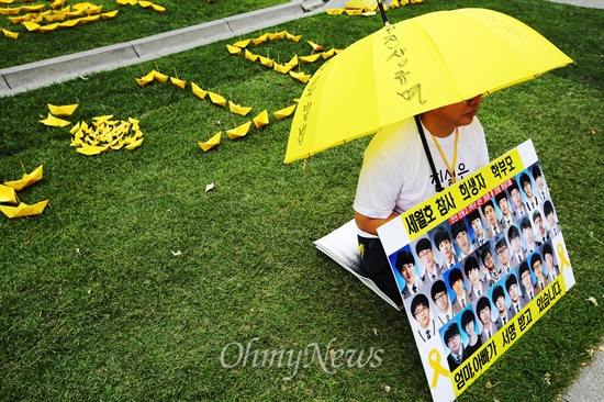 '아이들을 위해 서명 부탁드립니다' 세월호침몰사고 유가족들이 17일 오후 서울 광화문 광장 이순신 동상 앞에서 세월호특별법 제정을 위한 천만인서명운동을 위해 희생된 단원고 학생들 사진이 있는 피켓을 들고 있다.