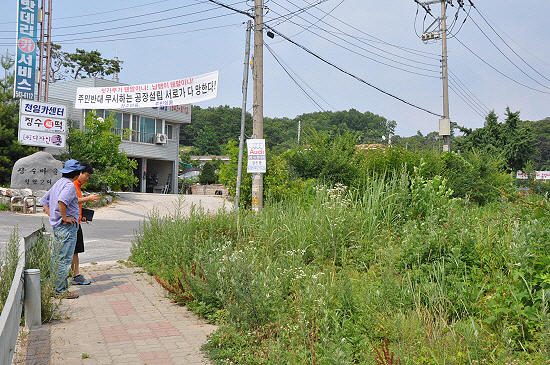 마을 주민들이 공장 예정부지를 보여주며, 주민들은 절대 공장입주를 허용할 수 없다고 밝혔다.  

