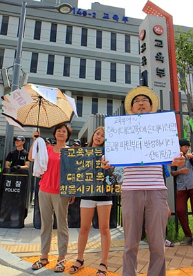 대안학교 여학생이 교육부 세종청사에서 '교육부는 법제화로 대안교육 침몰시키지 마라'고 적힌 피켓을 들고 시위하고 있다.
