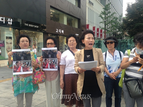  지난 18일 광화문광장에 나타난 '엄마부대 봉사단' 회원과 지난 4월 박근혜 대통령의 세월호 희생자 합동분향소 방문 당시 '조문 연출' 의혹을 받은 오아무개씨는 서로 다른 사람인 것으로 오마이뉴스 취재 결과 확인됐다. 왼쪽에서 세번째 안경 쓴 흰  옷 입은 사람이 동일 인물 의혹을 받은 김아무개씨.