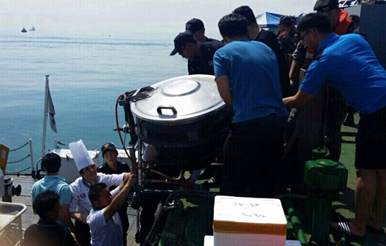 지난 20일, 바지선에서 일하는 민간잠수사들에게 자장면이 배달되고 있다.
