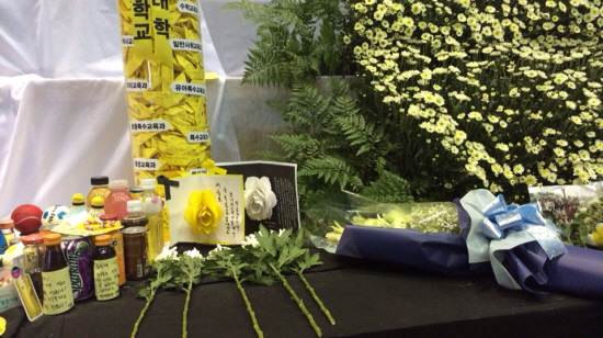 세월호 참사 피해자 선생님의 제단 아래에 친구들이 접어놓은 종이배가 놓여있다. 