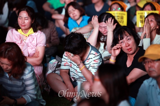 24일 오후 서울광장에서 열린 '세월호 참사 100일 추모 문화제'에서 참가한 시민들이 희생자들의 영상을 보며 눈물을 흘리고 있다.