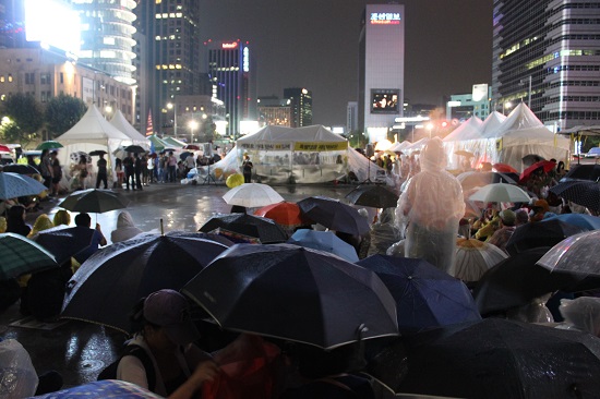 광화문 세종대왕상 앞에 모인 유가족과 시민들이 경찰의 장벽에 둘러싸인채 밤늦도록 함께 노래를 부르며 슬픔을 나눴다.