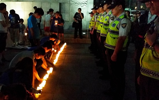  26일 오후 서울 광화문광장에서 열린 '수사권, 기소권 있는 진상규명 특별법 촉구 국민촛불' 도중인 오후 8시부터 경찰이 해산경고방송을 내보내고 인력을 증원하자 집회 참석자들이 경찰 앞에 '촛불벽'을 만들고 있다. 