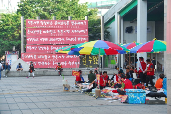 25일 수원역 앞 시위에서 걸었던 현수막 앞에서 단식투쟁을 하고 있다