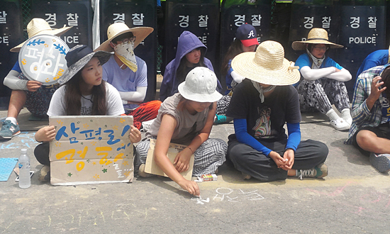 삼평리 송전탑 투쟁에 연대온 참가자가 '삼평리에 평화를'이라고 쓰인 피켓을 들고 있다.
