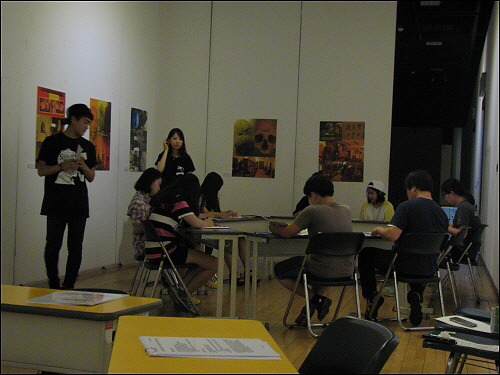 테이블에 앉아서 보고서를 작성하는 참가자들