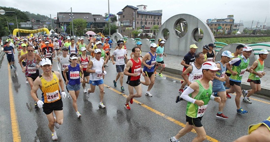 제5회 함양 산삼마라톤대회가 3일 오전 경남 함양군 상림공원에서 열린 가운데 참가자들이 빗속을 힘차게 달리고 있다.