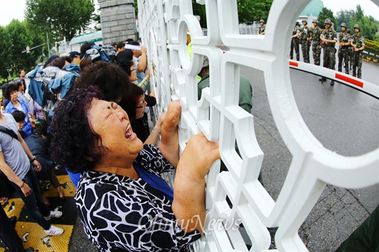 굳게 닫힌 국방부 문을 붙들고 한민구 장관에게 눈물로 호소하는 고 권오성 일병 어머니 김옥자씨.