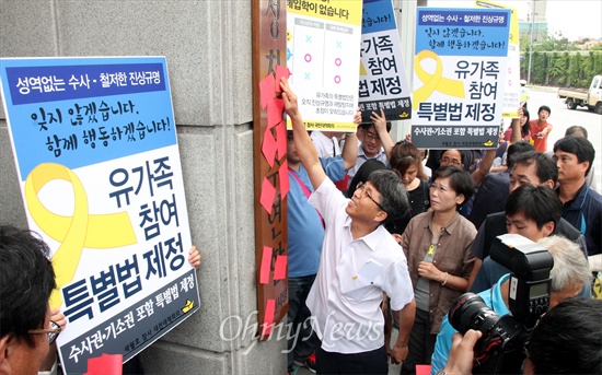 세월호참사 대전대책회의가 8일 오전 새정치민주연합 대전시당사 앞에서 기자회견을 열어 세월호특별법 여야 합의를 야합이라며 규탄한 뒤, 새정치민주연합 대전광역시당 현판에 레드카드를 붙이는 퍼포먼스를 펼치고 있다.