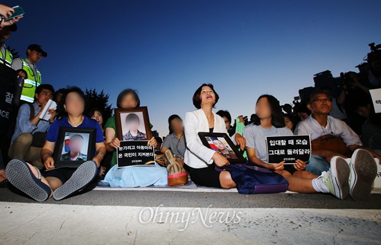   8일 오후 서울 용산구 국방부 앞에서 열린 28사단 폭행 사망 희생자 윤일병과 군 사망 희생자 추모제에서 희생자 영정을 든 유가족들과 시민들이 참가하고 있다. 