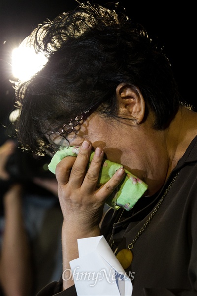 선임병들의 구타로 숨진 육군 28사단 윤일병의 어머니가 8일 저녁 서울 용산구 국방부 정문 앞에서 열린 추모제에서 아들에게 보내는 편지를 읽으며 눈물을 훔치고 있다.