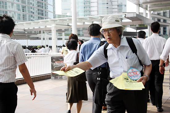 도쿄 중심가인 시나가와역 앞에서 출근길 시민들을 상대로 전단지를 배포하고 있는 나고야 소송 지원회 회원들. 2010년 8월 10일.