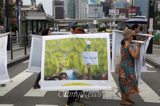 수사권과 기소권이 보장되는 세월호 특별법 제정을 촉구하는 사진가들이 11일 정오 국회를 출발해서 유가족이 단식농성중인 광화문광장까지 4시간 16분동안 세월호 참사 관련 사진을 들고 걸어가는 '4시간16분 동안의 도보전시'를 하고 있다.