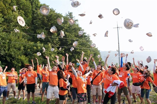 참가자들이 모자를 하늘로 향해서 던지는 퍼포먼스를 하고 있다.