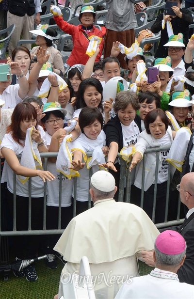 프란치스코 교황이 15일 대전월드컵경기장에서 열린 '성모승천대축일미사'에 입장하며, 세월호참사 유가족들을 위로하기 위해 다가가고 있다.