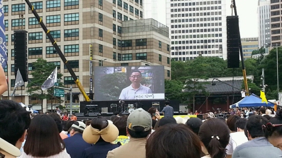 서울광장에 모인 시민들에게 방송인 김제동씨의 영상인사가 전해졌다.